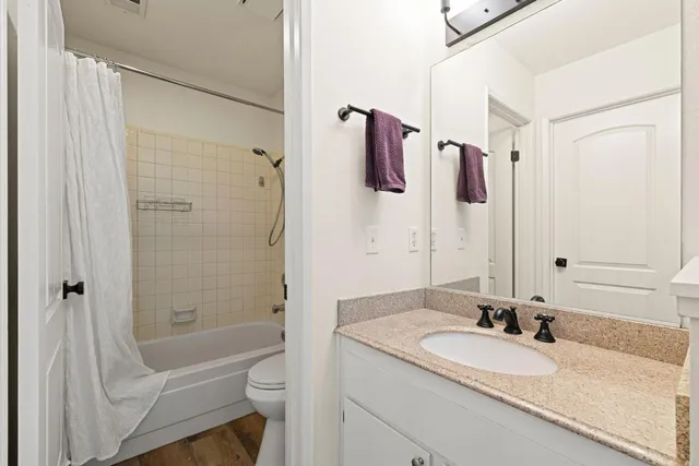 a bathroom with a granite countertop sink toilet and shower