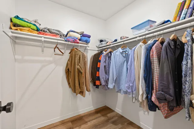 a view of walk in closet with clothes and shoes