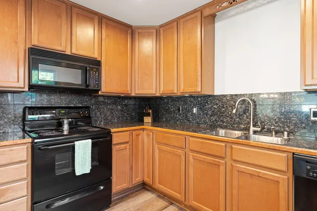 a kitchen with granite countertop wooden cabinets and a stove top oven
