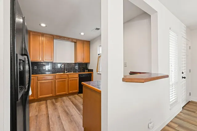 a kitchen with stainless steel appliances granite countertop a refrigerator and a stove top oven