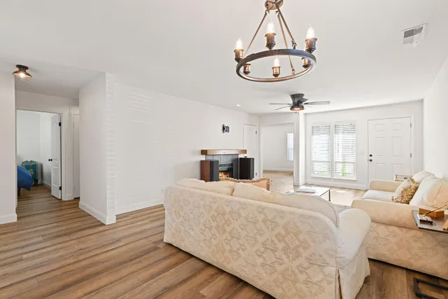 a living room with furniture a window and a chandelier