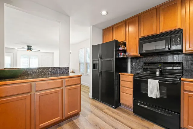 a kitchen with stainless steel appliances granite countertop a refrigerator stove and sink