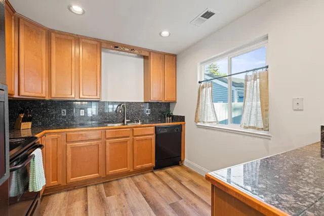 a kitchen with stainless steel appliances granite countertop cabinets and wooden floor