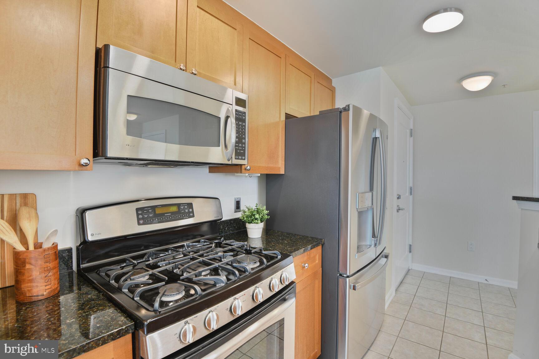 930 Wayne Avenue, Unit 1403 Silver Spring, MD 20910 - Photo 14 of 37 a kitchen with stainless steel appliances granite countertop a stove a refrigerator and a microwave