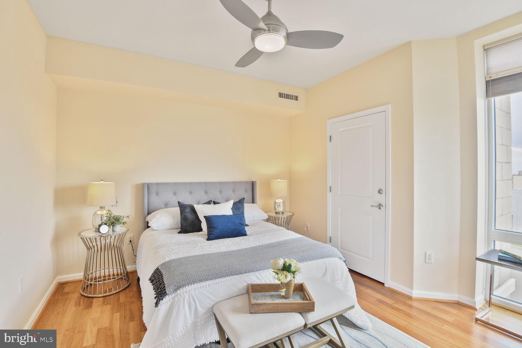 930 Wayne Avenue, Unit 1403 Silver Spring, MD 20910 - Photo 15 of 37 a bedroom with a bed and wooden floor