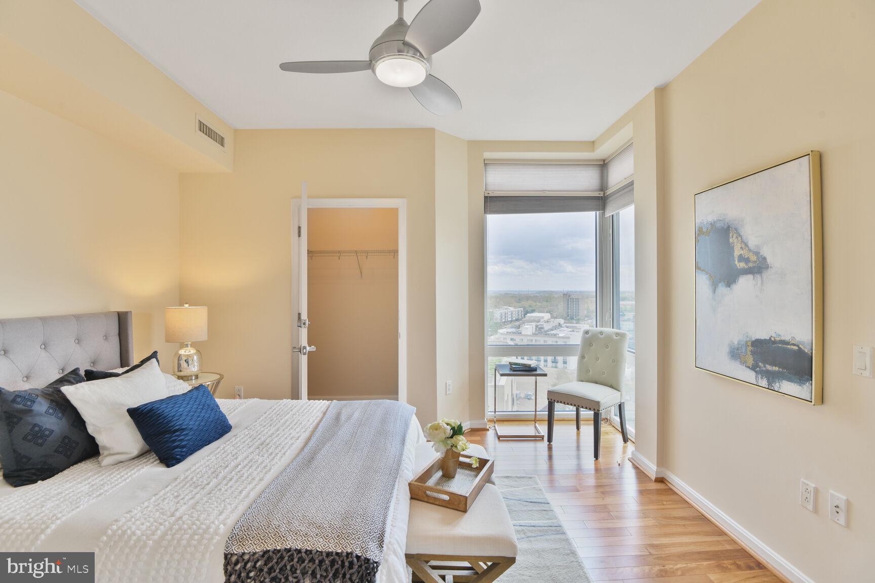 930 Wayne Avenue, Unit 1403 Silver Spring, MD 20910 - Photo 16 of 37 a bedroom with a bed and a large mirror with wooden floor