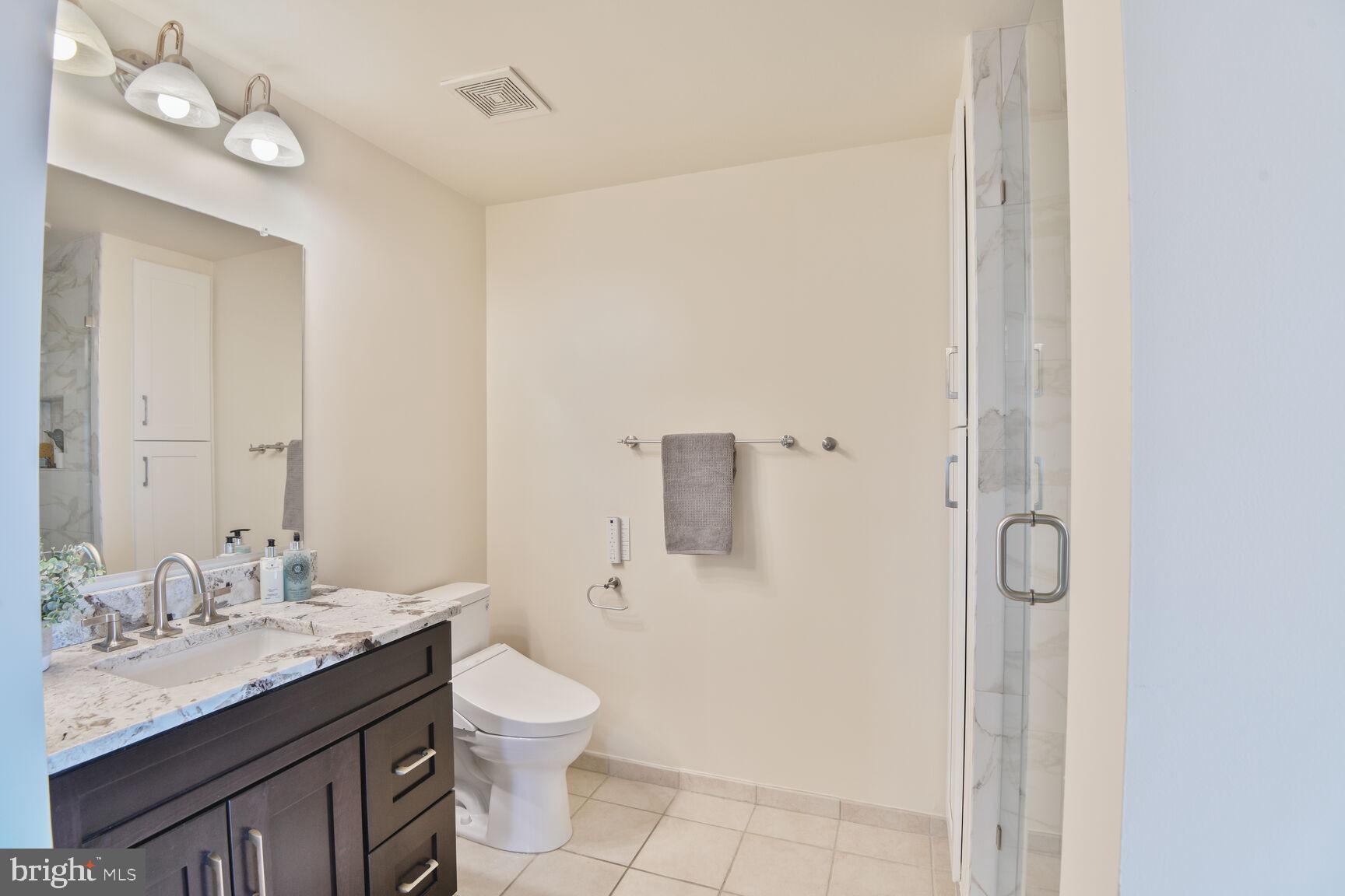 930 Wayne Avenue, Unit 1403 Silver Spring, MD 20910 - Photo 20 of 37 a bathroom with a granite countertop sink a toilet and shower