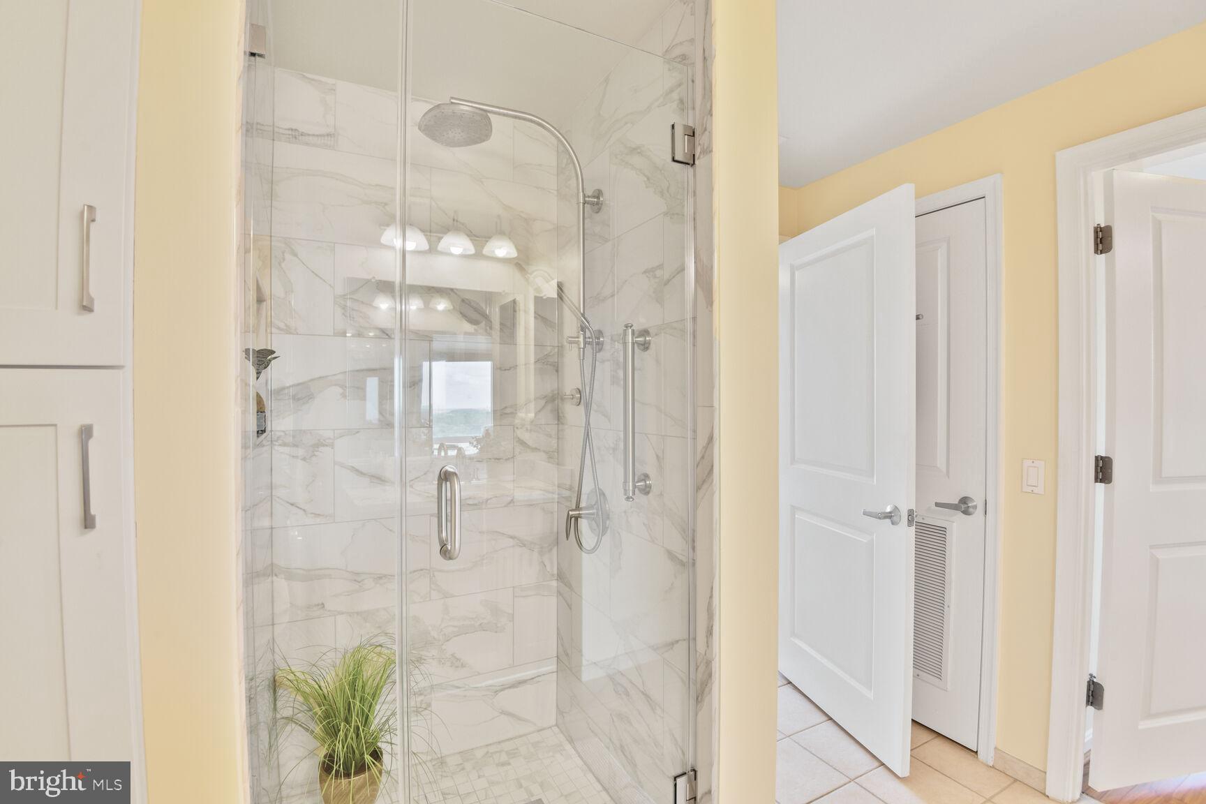 930 Wayne Avenue, Unit 1403 Silver Spring, MD 20910 - Photo 22 of 37 a bathroom with a glass shower door