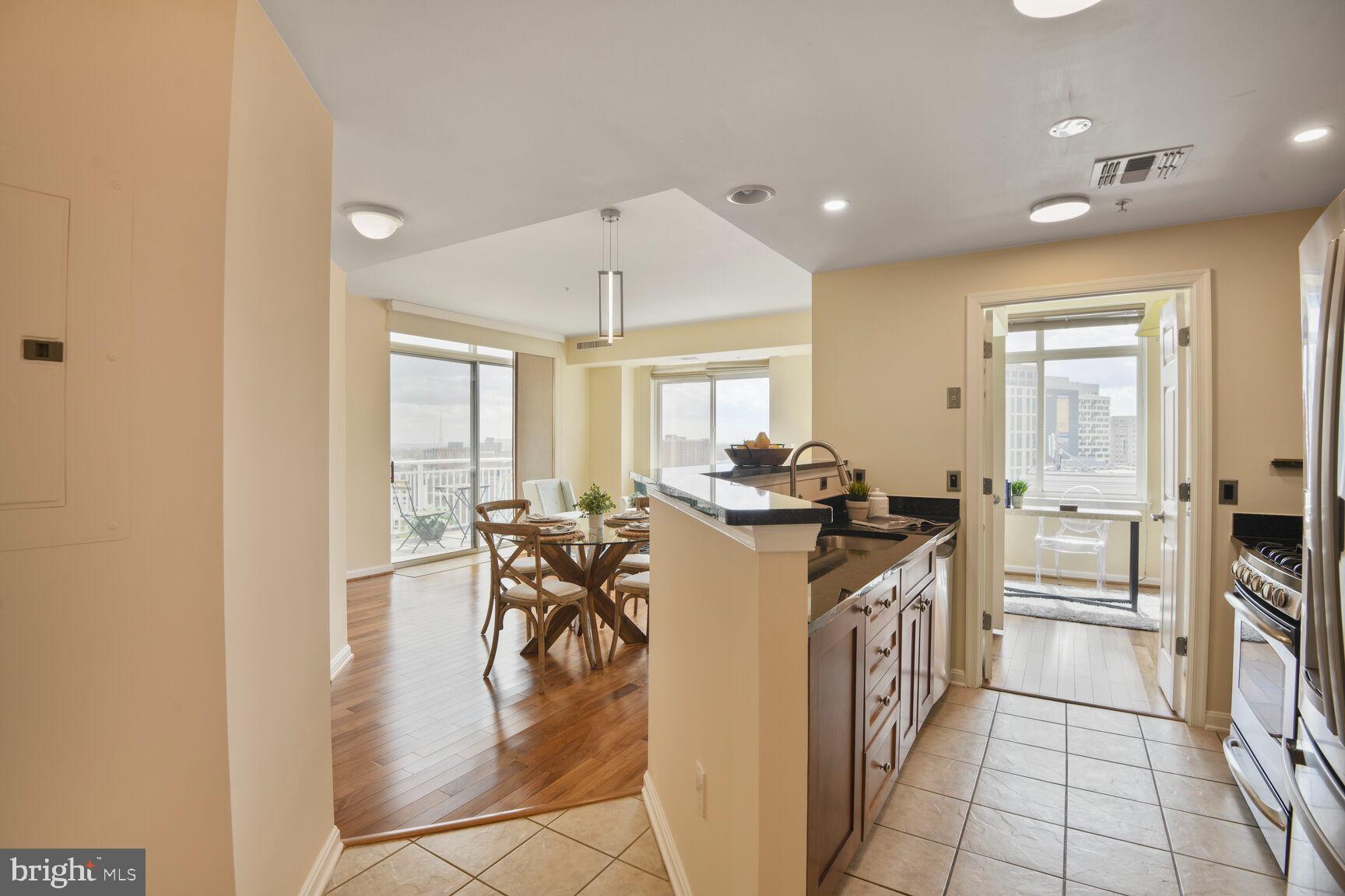 930 Wayne Avenue, Unit 1403 Silver Spring, MD 20910 - Photo 23 of 37 a kitchen with stainless steel appliances granite countertop a stove top oven a sink a dining table and chairs