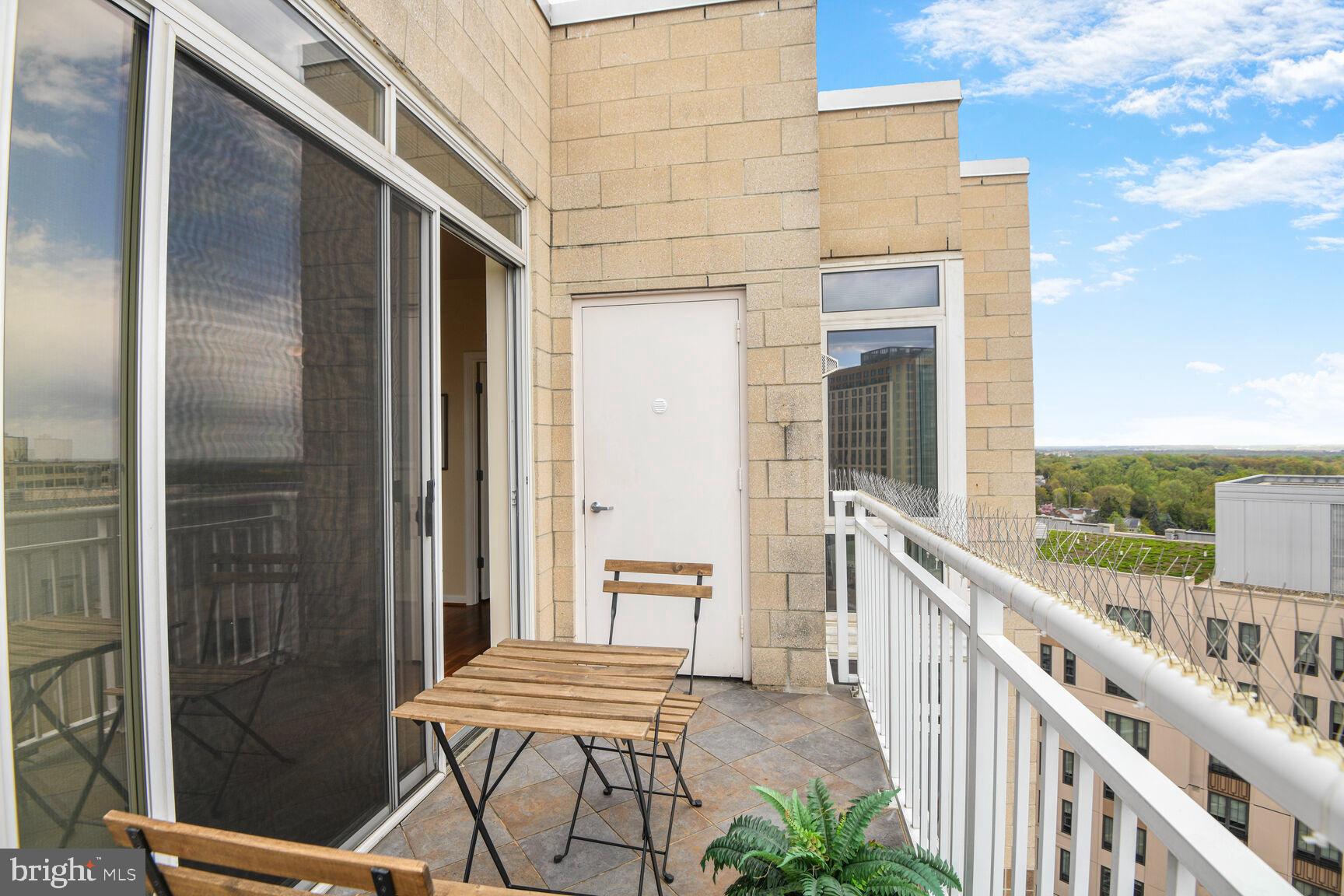 930 Wayne Avenue, Unit 1403 Silver Spring, MD 20910 - Photo 28 of 37 a view of a balcony with furniture and floor to ceiling window
