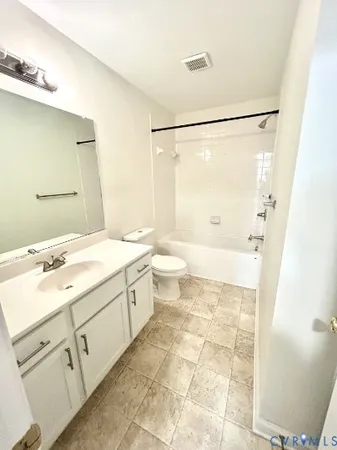 a spacious bathroom with a double vanity sink toilet mirror and a shower