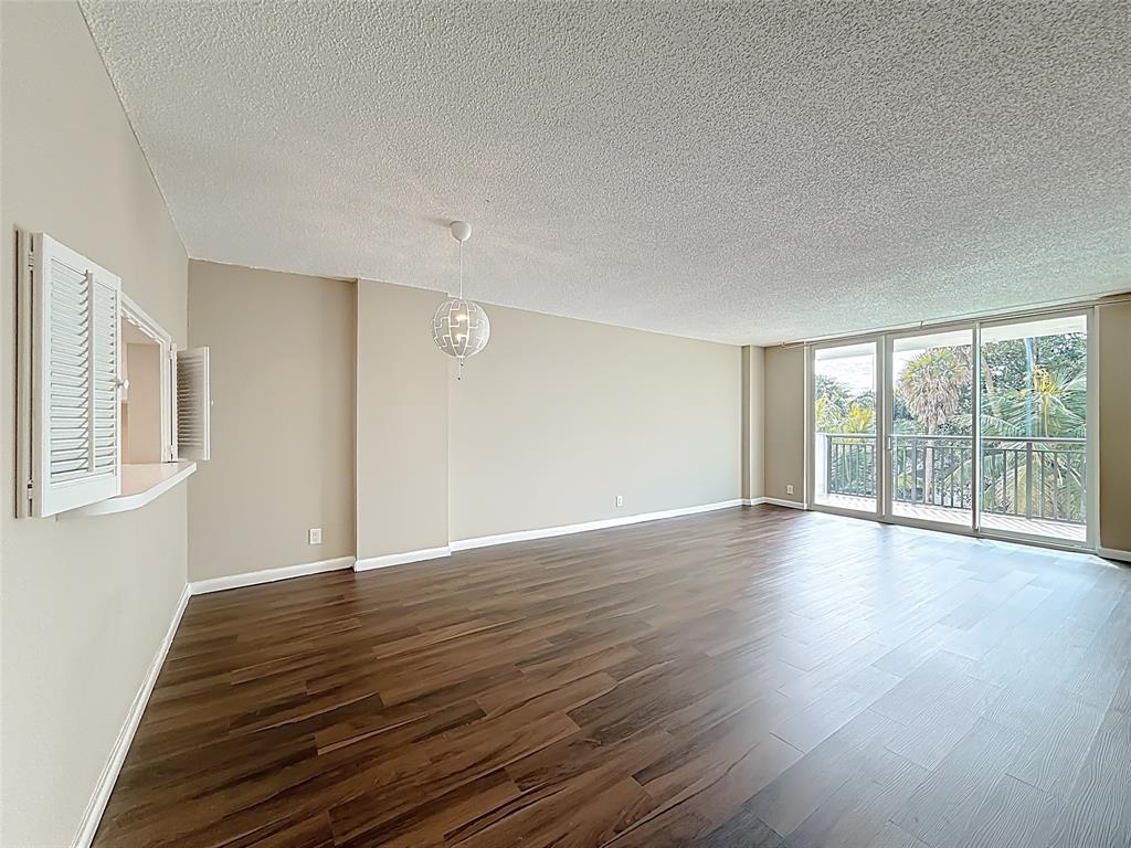 1147 Hillsboro Mile, Unit 506 Hillsboro Beach, FL 33062 - Photo 13 of 45 a view of an empty room with wooden floor and a window