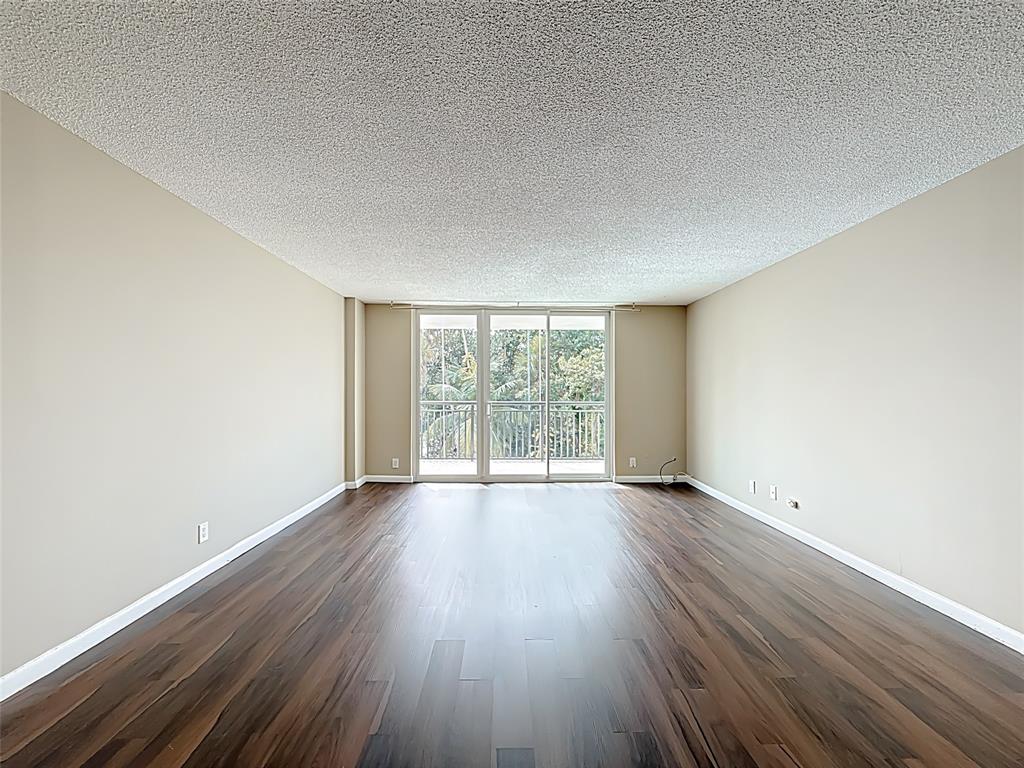 1147 Hillsboro Mile, Unit 506 Hillsboro Beach, FL 33062 - Photo 14 of 45 an empty room with wooden floor and windows