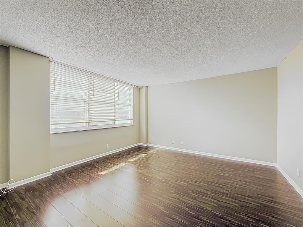 1147 Hillsboro Mile, Unit 506 Hillsboro Beach, FL 33062 - Photo 22 of 45 a view of an empty room with wooden floor and a window