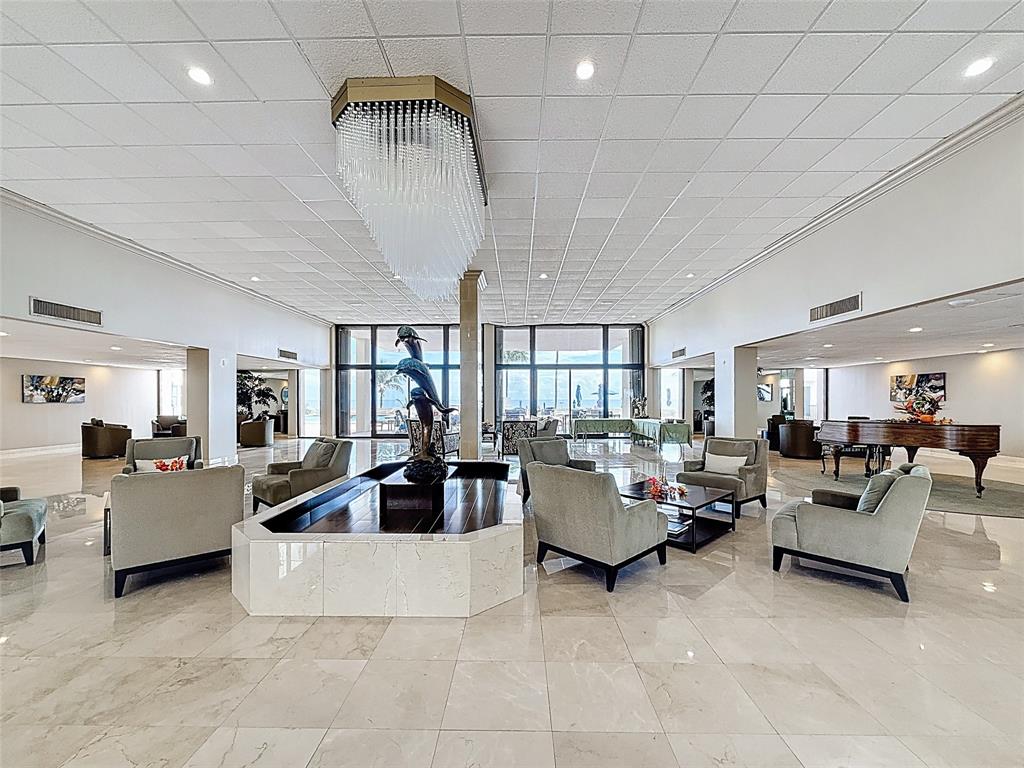 1147 Hillsboro Mile, Unit 506 Hillsboro Beach, FL 33062 - Photo 6 of 45 a living room with furniture and a chandelier