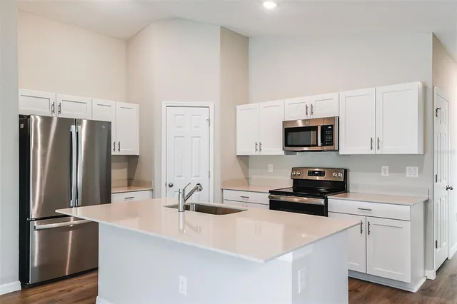a kitchen with stainless steel appliances a sink a stove a microwave and cabinets