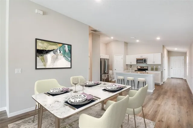 a kitchen with stainless steel appliances kitchen island granite countertop a dining table and chairs