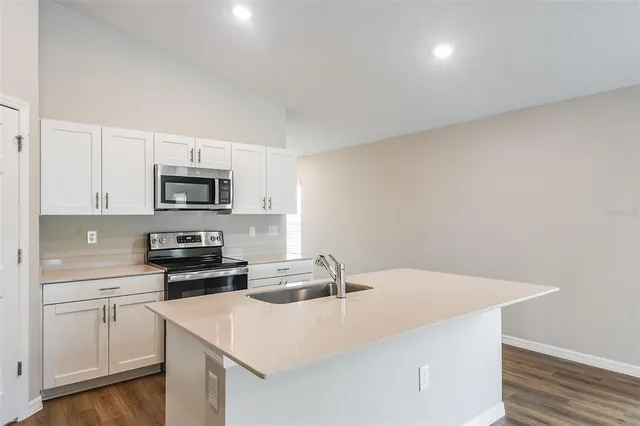 a kitchen with stainless steel appliances a white stove top oven and white cabinets