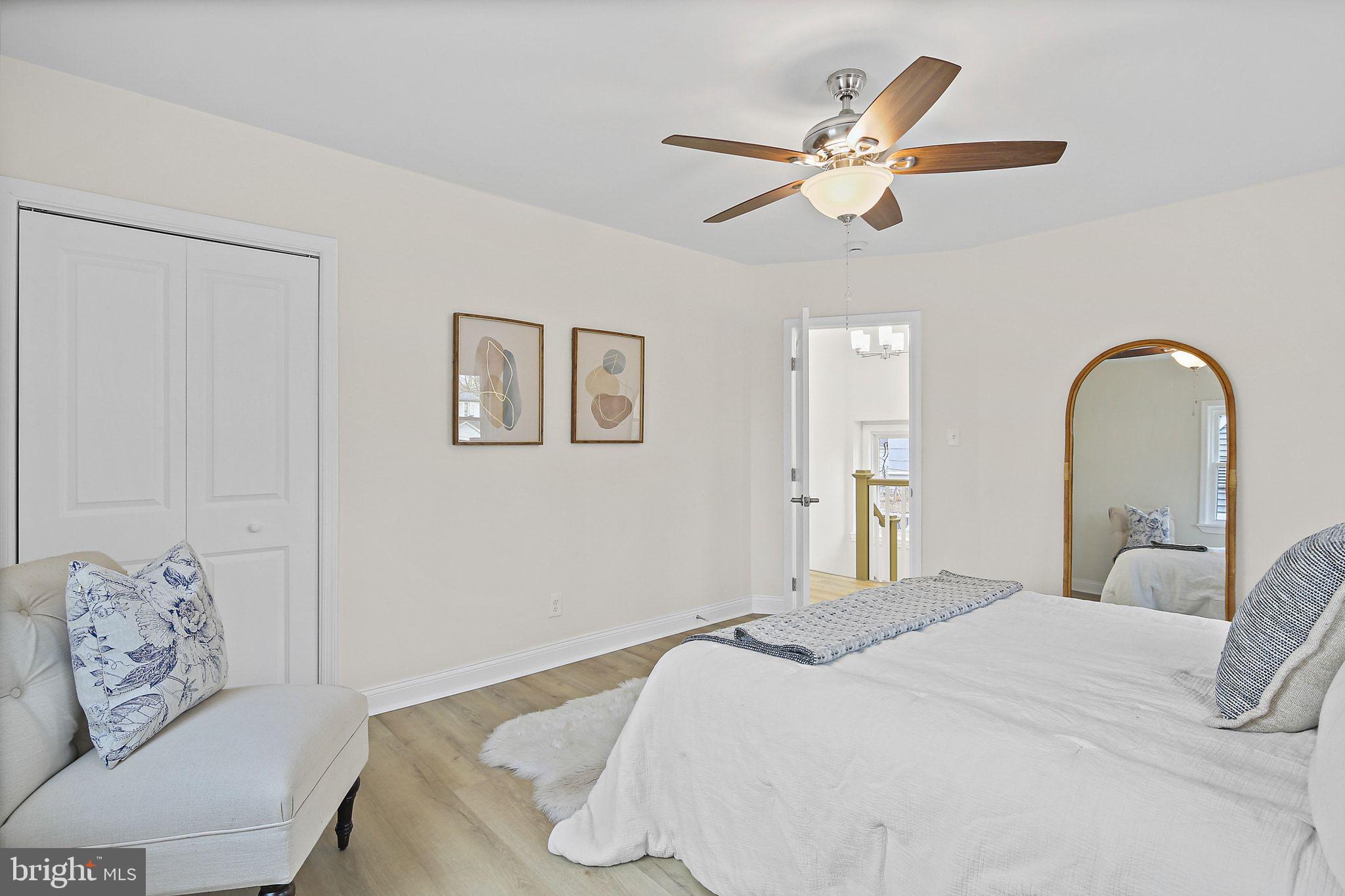 402 Westgate Road Baltimore, MD 21229 - Photo 15 of 34 a bedroom with a large bed and a chandelier