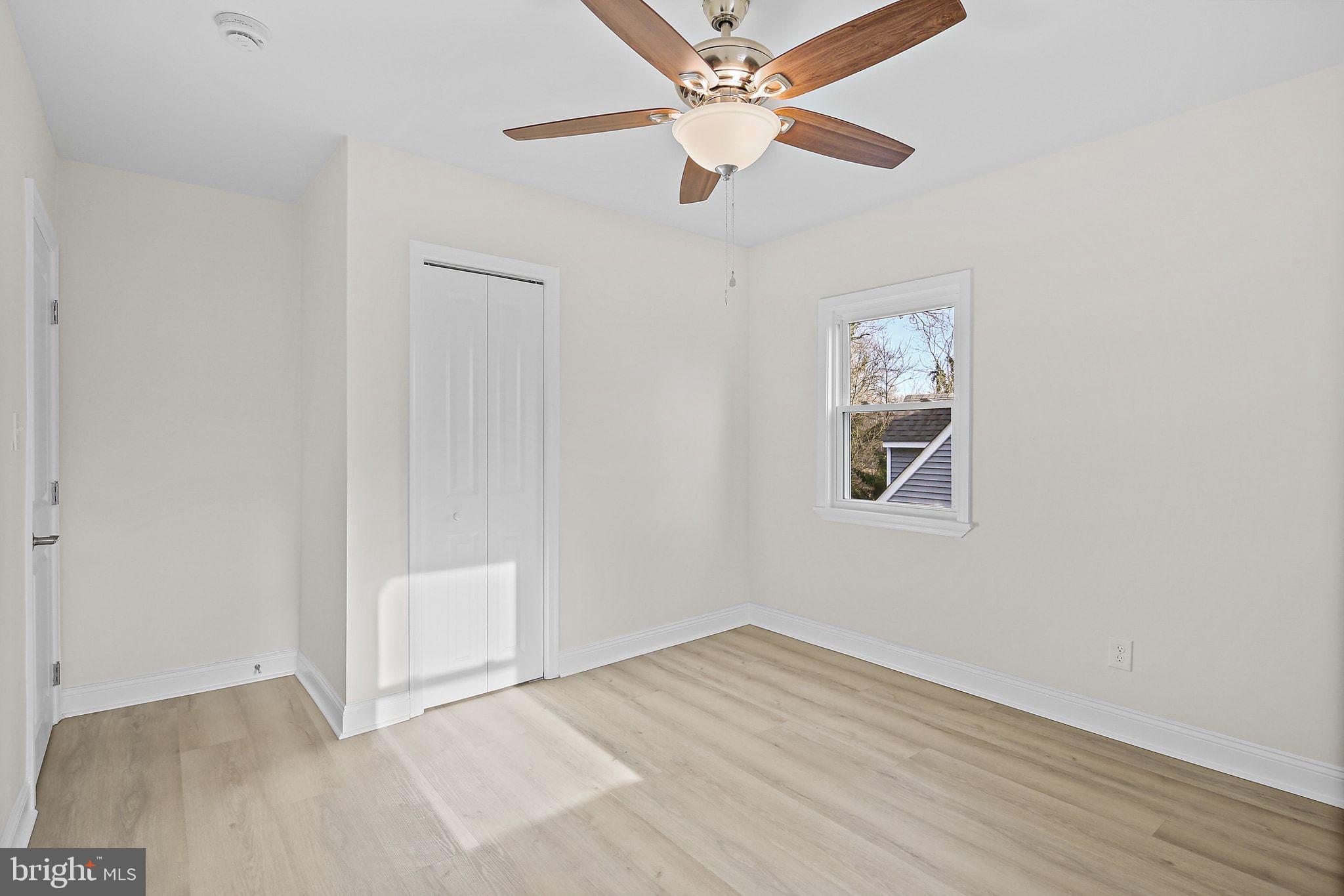 402 Westgate Road Baltimore, MD 21229 - Photo 23 of 34 an empty room with wooden floor ceiling fan and window