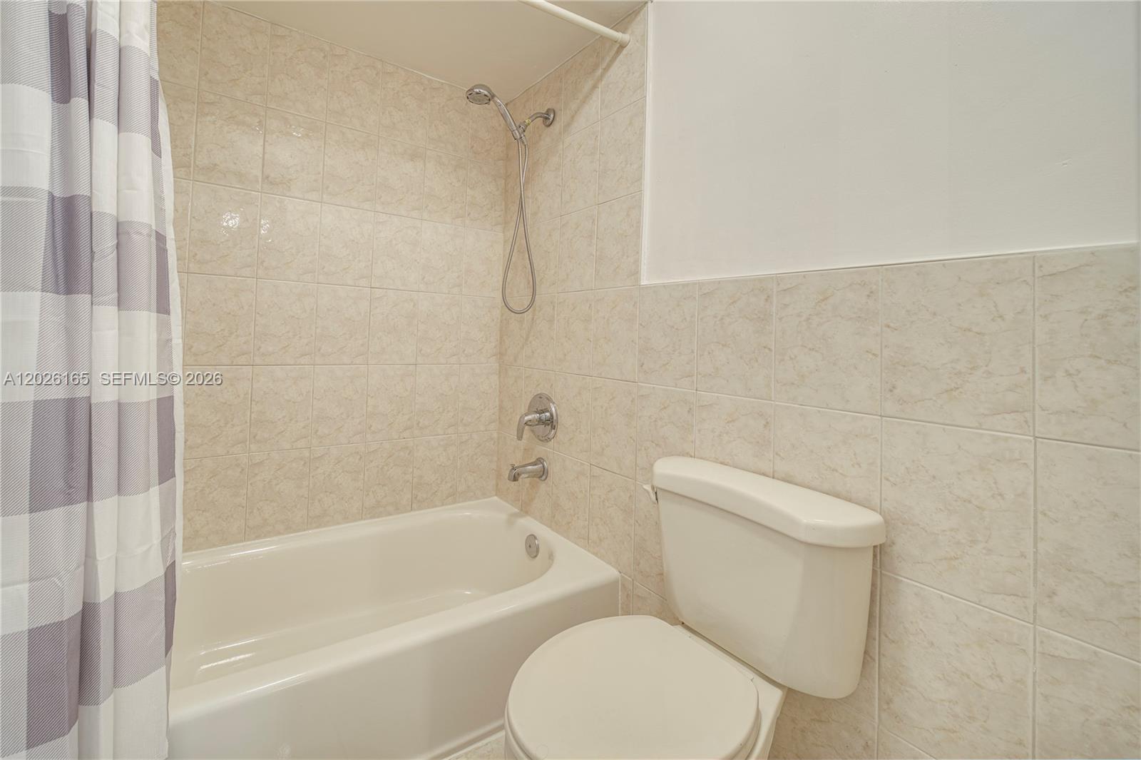 13337 Southwest 64th Lane Miami, FL 33183 - Photo 25 of 36 a white toilet and tub sitting next to a bathroom sink