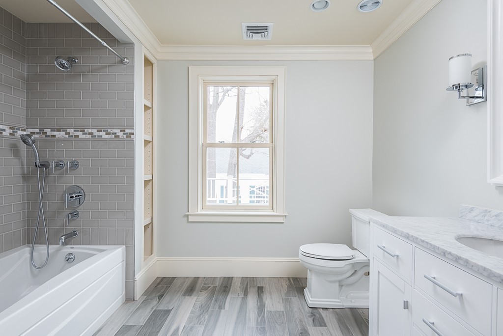 392 Main Street Hingham, MA 02043 - Photo 22 of 30 a bathroom with a granite countertop toilet a sink and bathtub