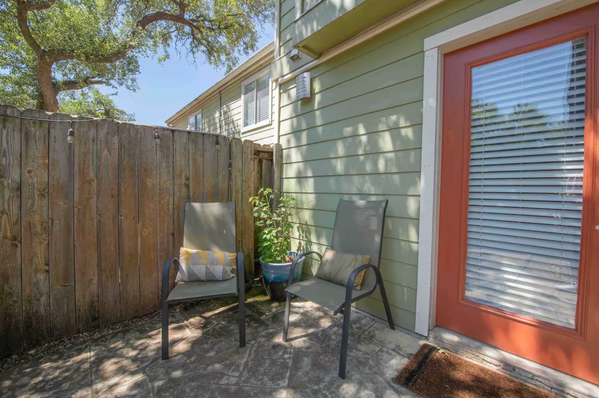 3601 Menchaca Road, Unit 107 Austin, TX 78704 - Photo 13 of 15 a backyard of a house with chairs and a tree