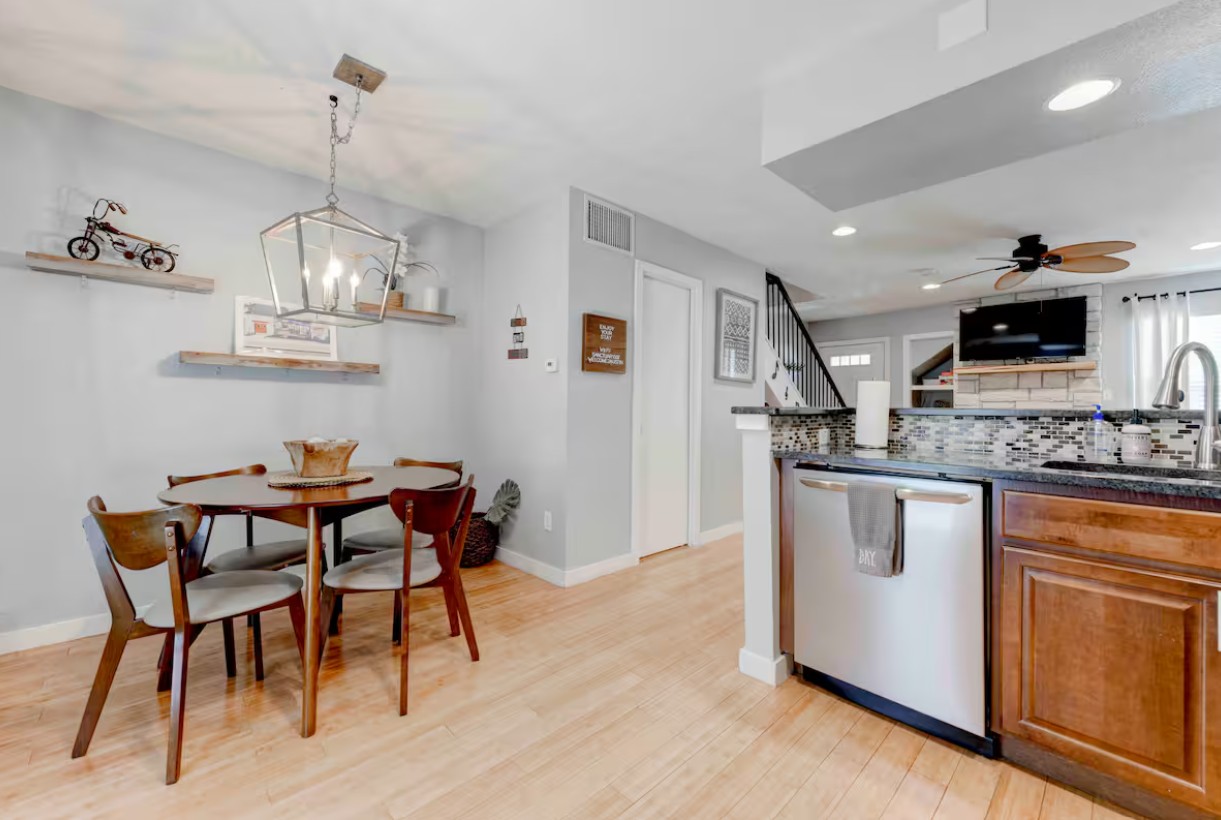 3601 Menchaca Road, Unit 107 Austin, TX 78704 - Photo 7 of 15 a kitchen with stainless steel appliances kitchen island granite countertop a table chairs sink and cabinets