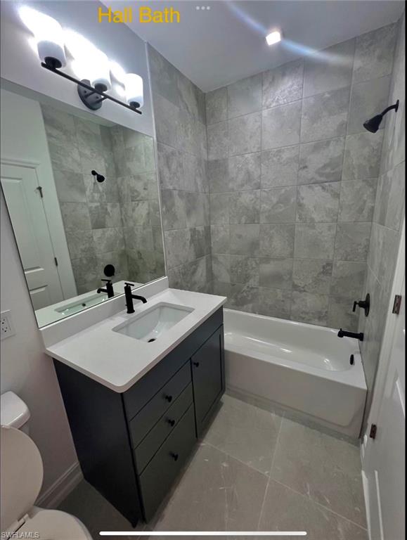 7452 Rockefeller Drive Naples, FL 34119 - Photo 11 of 19 a bathroom with a sink mirror toilet and bathtub