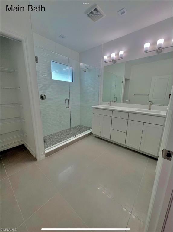 7452 Rockefeller Drive Naples, FL 34119 - Photo 14 of 19 a bathroom with a double vanity sink and mirror