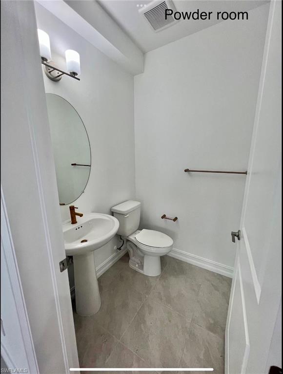 7452 Rockefeller Drive Naples, FL 34119 - Photo 17 of 19 a white toilet sitting next to a bathroom sink