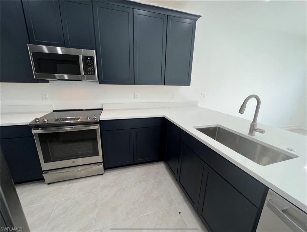 7452 Rockefeller Drive Naples, FL 34119 - Photo 2 of 19 a kitchen with a stove and a microwave