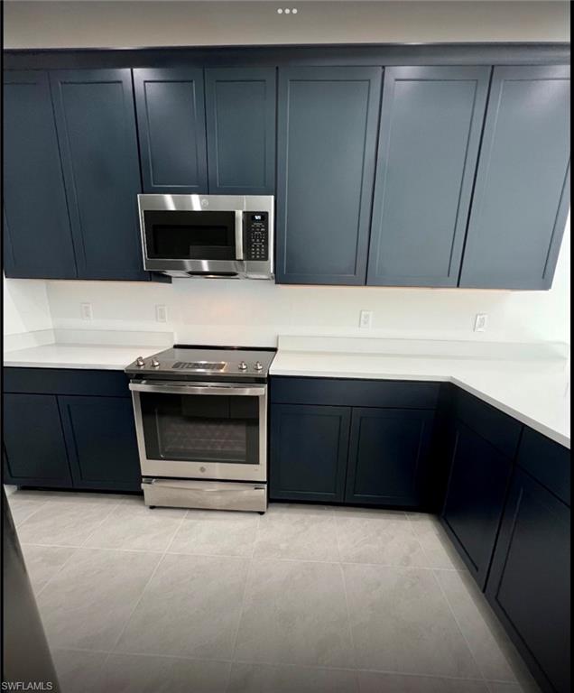 7452 Rockefeller Drive Naples, FL 34119 - Photo 3 of 19 a kitchen with a stove and a microwave