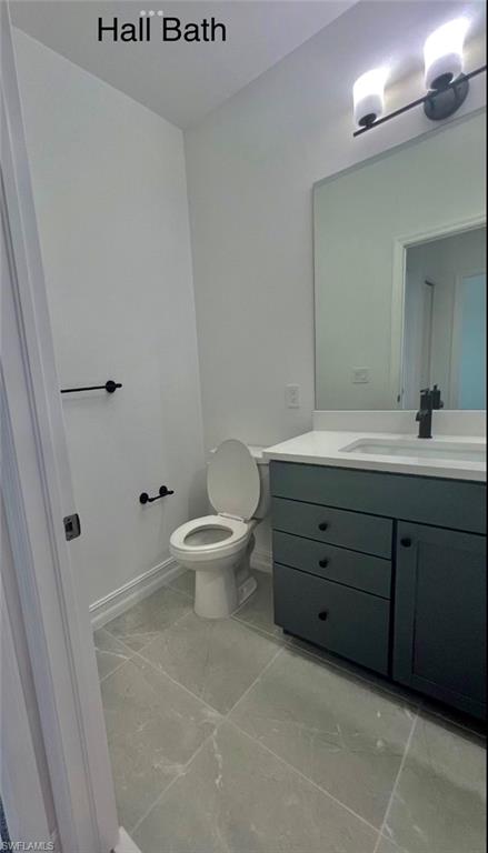 7452 Rockefeller Drive Naples, FL 34119 - Photo 10 of 19 a bathroom with a toilet a sink and mirror
