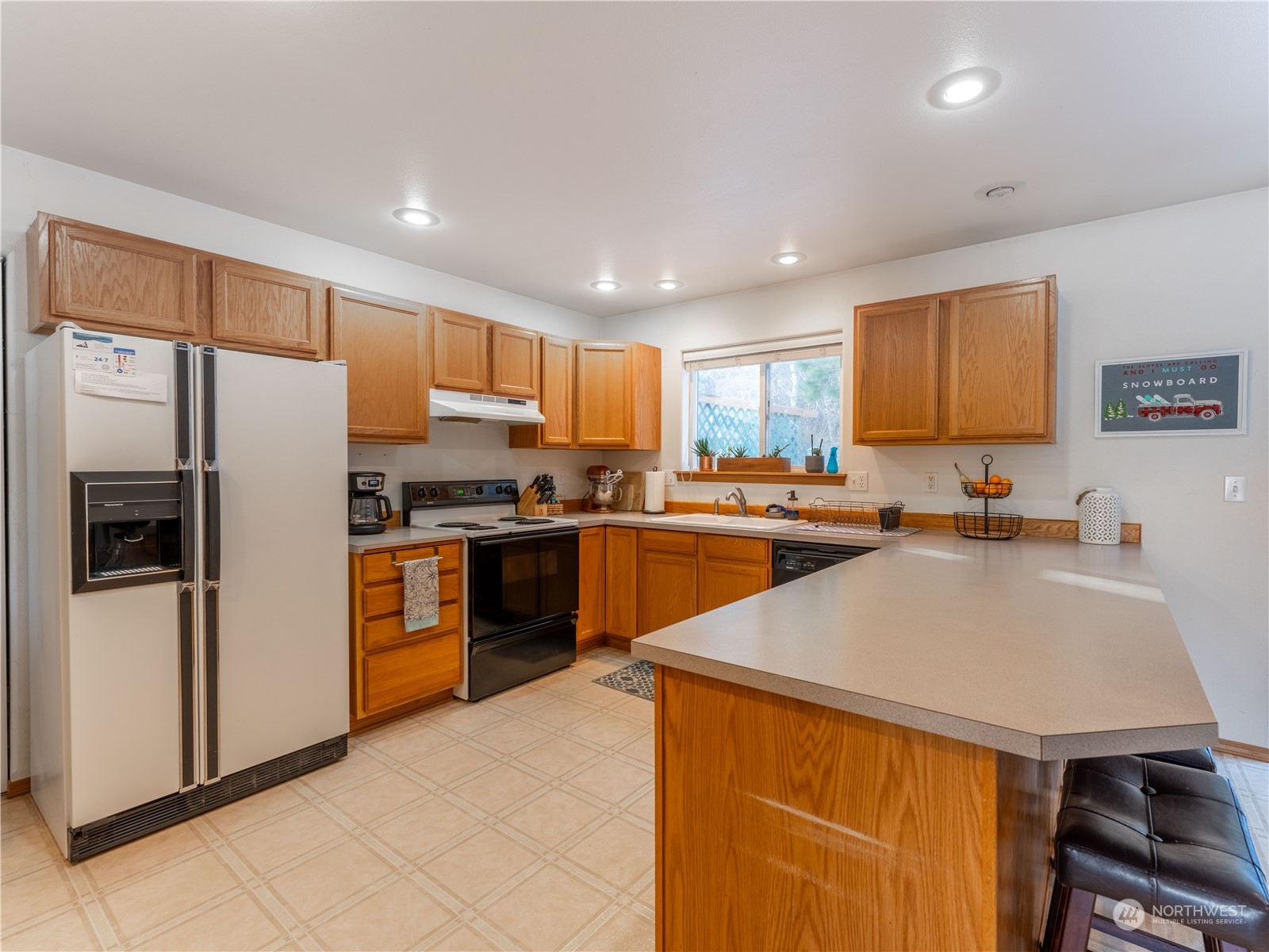 14918 Burkey Street Entiat, WA 98822 - Photo 11 of 39 a kitchen with a refrigerator a sink and wooden cabinets