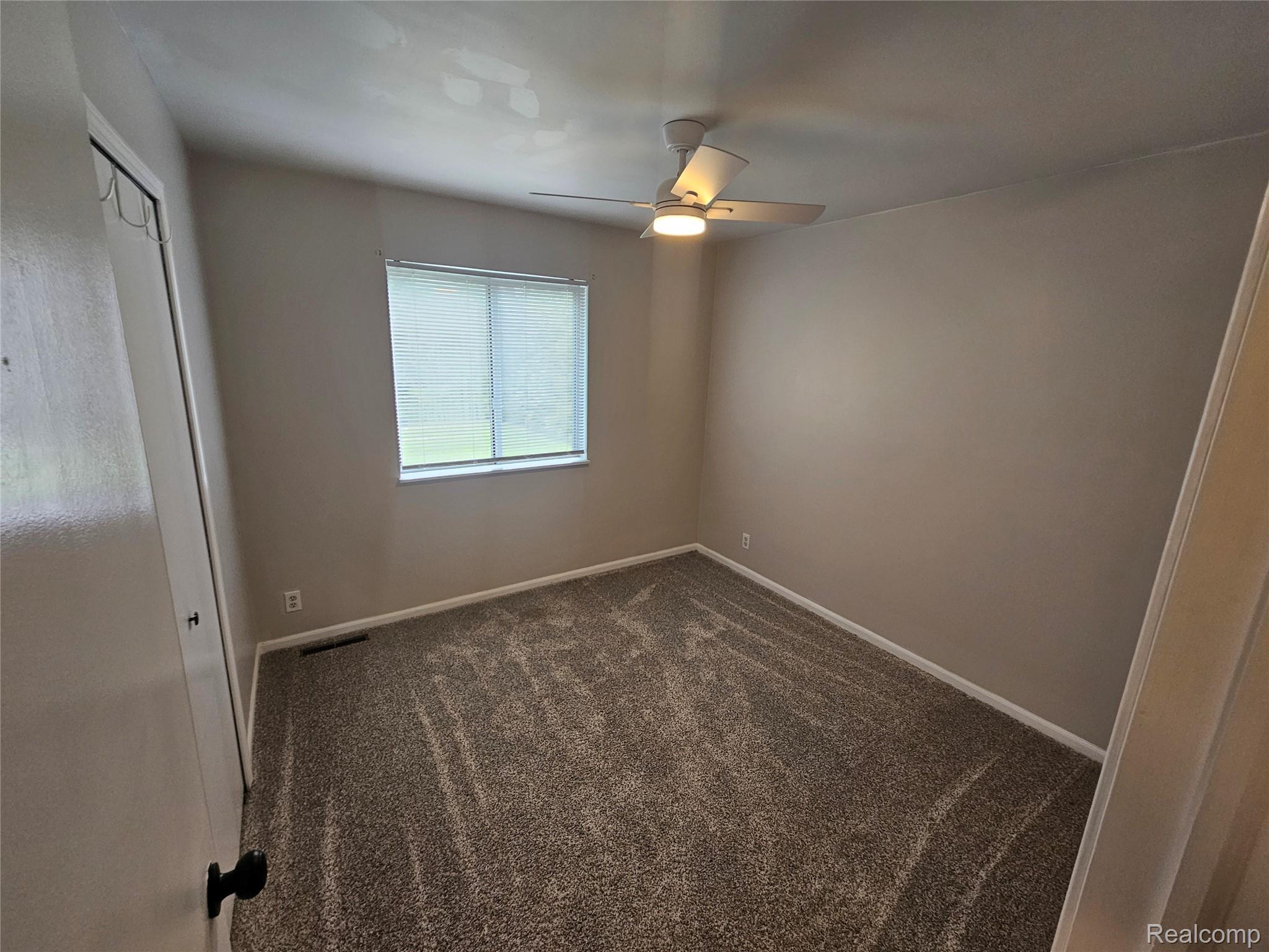 1210 Bay Ridge Drive Highland, MI 48356 - Photo 15 of 25 Unfurnished bedroom featuring a closet, dark colored carpet, and a ceiling fan