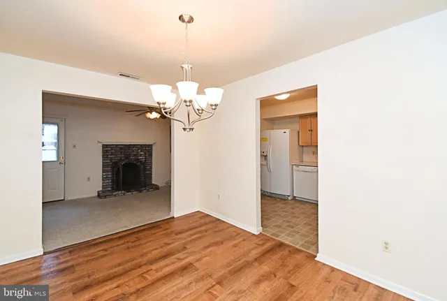 a view of a livingroom with a chandelier fan and a kitchen counter space
