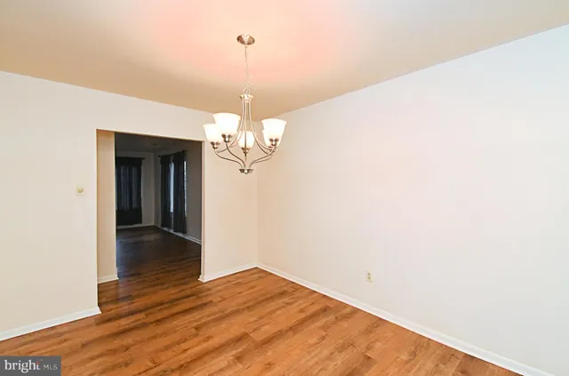 a view of a room with wooden floor and chandelier