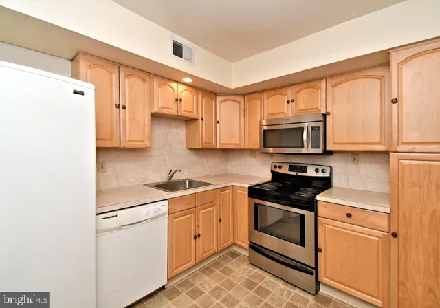 a kitchen with stainless steel appliances white cabinets and a sink