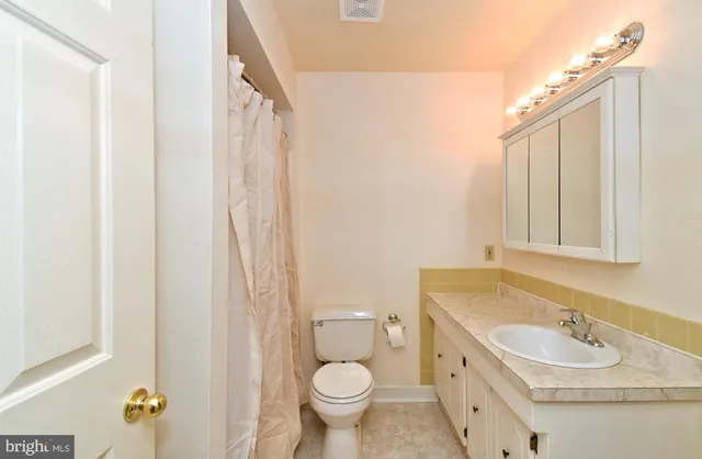 a white toilet sitting next to a bathroom sink
