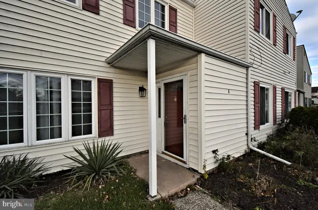 a view of a house with a large window and potted plants