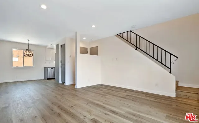 a view of a hallway with wooden floor and entryway