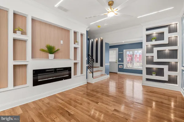 a living room with a fireplace windows and a ceiling fan