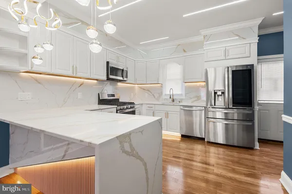 a kitchen with stainless steel appliances granite countertop a sink stove and microwave