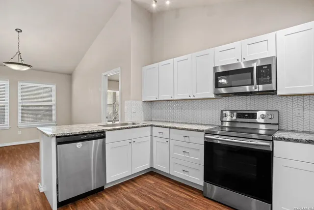 a kitchen with stainless steel appliances granite countertop a sink and stove top oven