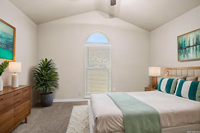 a bedroom with a bed and a potted plant