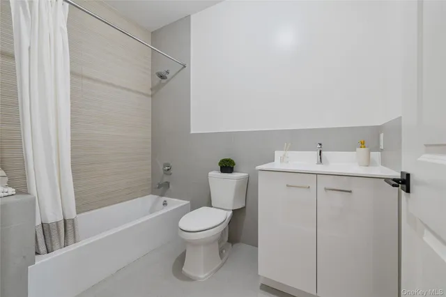 a white toilet sitting next to a bath tub