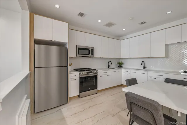 a kitchen with a refrigerator a stove top oven a sink and cabinets