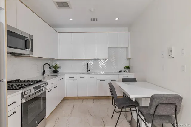 a kitchen with a stove a sink a microwave and cabinets