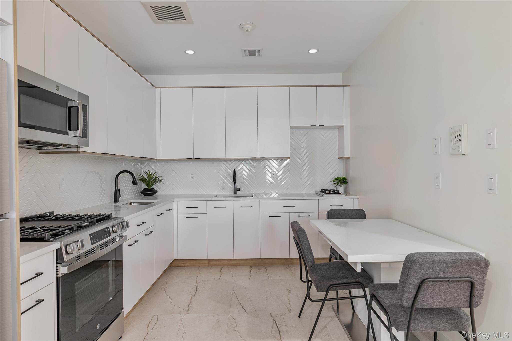 17 Union Road, Unit 110 Spring Valley, NY 10977 - Photo 7 of 16 a kitchen with a stove a sink a microwave and cabinets